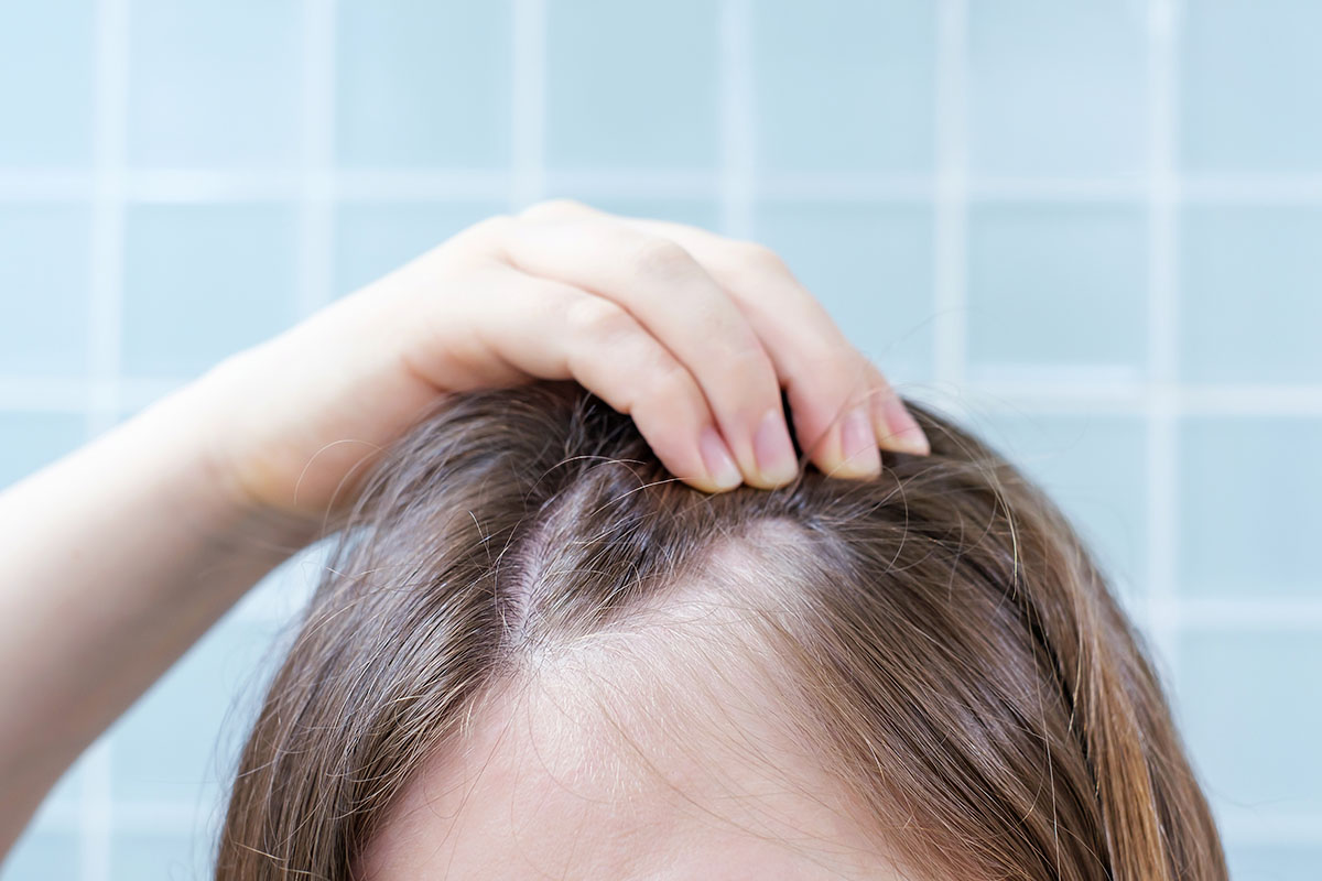 woman-touching-her-hair-close-up-against-backgroun-2026-03-25-08-20-09-utc